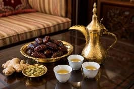 طريقة-عمل-قهوة عربية إماراتية بلون أشقر ذهبي مع الزنجبيل والهيل، تقدم في دلة وفناجين صغيرة مع التمر الفاخر في مجلس ضيافة عربي