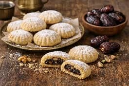طريقة-عمل-كحك العيد المحشو بالتمر (العجوة) والمكسرات، مع تمر مجفف وجوز على الجانب