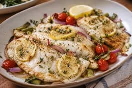 طريقة-عمل-فيليه سمك لبناني طري مخبوز بالفرن مع شرائح الليمون والزعتر الطازج، يقدم في طبق أنيق مع خضار جانبية