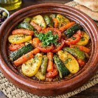 طريقة-عمل-طاجن خضار مغربي مطهو ببطء مع بهارات مغربية وزيت زيتون ويُقدَّم ساخنًا في طاجن فخاري