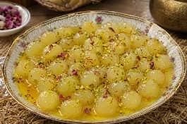 طبق حلوى الجبنة العمانية البيضاء المطاطية في قطر الزعفران والهيل وماء الورد مع فستق حلبي