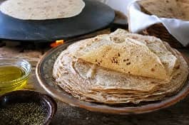 طريقة-عمل-خبز شراك تونسي رقيق جداً مصنوع من القمح الكامل، يُخبز على الصاج الساخن ويرص في طبق مع زيت الزيتون والزعتر