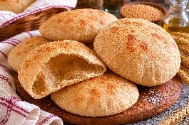 عيش حبة كاملة مصري طري ومنتفخ مع جيب هوائي رائع، بني ذهبي على صينية خبز