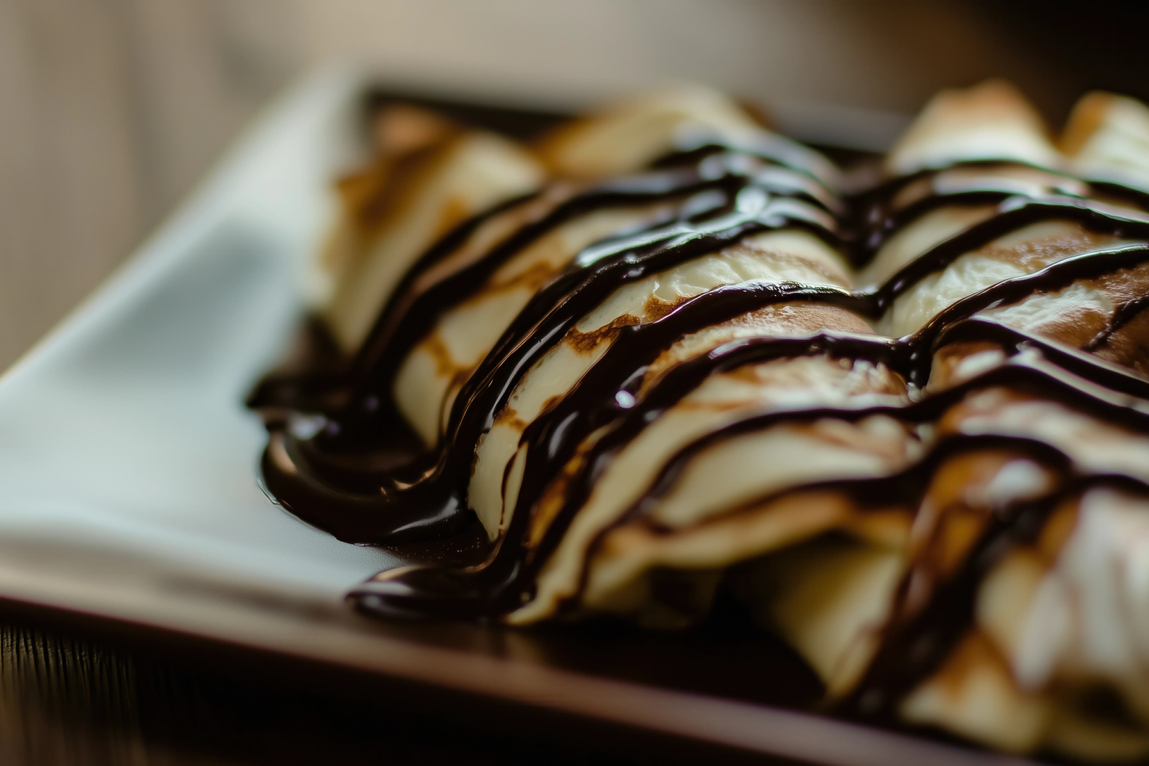 كريب فرنسي رقيق محشو بالشوكولاتة الذائبة ومزين بالسكر البودرة ومقدم بشكل منزلي شهي