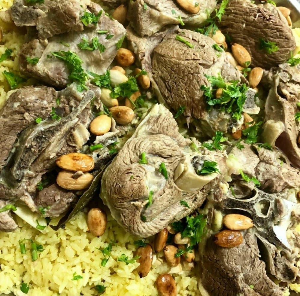 منسف أردني تقليدي بلحم الضأن المطهو بلبن الجميد والمقدم مع الأرز البسمتي وخبز الشراك بطريقة أصيلة