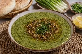 طريقة-عمل-طبق بصارة مصرية خضراء كريمية مزينة بزيت الزيتون والبقدونس الطازج وتقدم مع خبز بلدي وبصل أخضر وفلفل حار