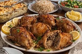 طريقة-عمل-حمام مصري محشي أرز ذهبي مقرمش يقدم في طبق مع مكرونة بالبشاميل وأرز بالشعرية وليمون