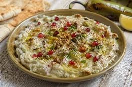 طريقة-عمل-متبل فليفلة عراقي مدخن بالطحينة الكريمية، مزين بزيت الزيتون وحبوب الرمان والخبز المحمص على جنب