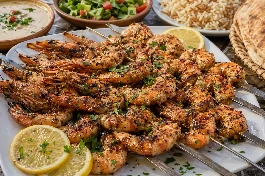 جمبري مصري مشوي على الفحم بأسياخ معدنية مع تتبيلة الليمون والثوم والكمون، يقدم مع شرائح الليمون والخبز البلدي والسلطة الخضراء