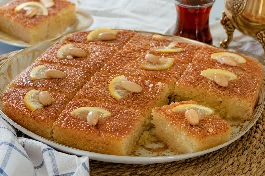 طريقة-عمل-صينية بسبوسة مصرية بالليمون، ذهبية اللون وطرية جداً، مشربة بقطر الليمون ومزينة بشرائح الليمون واللوز المحمص