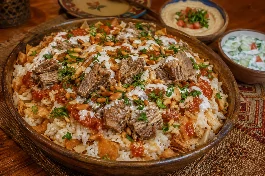 طبق فتة مصرية تقليدية في صينية عميقة، طبقات من الأرز الأبيض المفلفل والخبز المحمص المقرمش المغطى بقطع اللحم الطرية والصلصة الحمراء، يعلوها صوص الثوم والخل الأبيض، مزينة بالمكسرات المحمصة والبقدونس الطازج، بجانب سلطة الطحينة وسلطة الزبادي