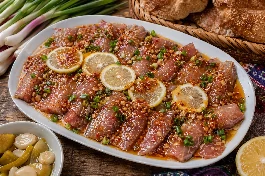 طريقة-عمل-طبق فسيخ بورى مقطع بعناية إلى شرائح لامعة، مزين بشرائح الليمون الأصفر اللامع، وعليه قطرات من الزيت الحار المتوهج مع البصل الأخضر وأرغفة الخبز البلدي الأسمر على جنب