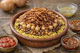 طريقة-عمل-طبق كشري مصري أصفر شهي مزين بالبصل المقرمش الذهبي والحمص وصلصة الدقة الحارة، يقدم في وعاء فخاري على الطراز الشعبي