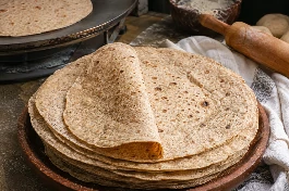 طريقة-عمل-خبز تورتيلا عراقي بالقمح الكامل مطاطي ورقيق، مخبوز على الصاج الساخن، ومكدس في طبق مع خبز طازج