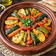 طريقة-عمل-طاجن خضار مغربي مطهو ببطء مع بهارات مغربية وزيت زيتون ويُقدَّم ساخنًا في طاجن فخاري