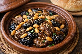 طريقة-عمل-طاجين مغربي تقليدي باللحم والبرقوق واللوز المحمص مع رشة سمسم، يقدم في طبق طاجين فخاري