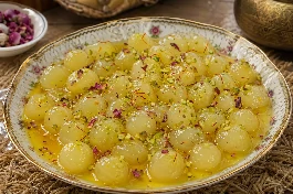 طبق حلوى الجبنة العمانية البيضاء المطاطية في قطر الزعفران والهيل وماء الورد مع فستق حلبي