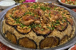 طبق مقلوبة فلسطيني مقلوب بشكل مثالي يظهر طبقات الأرز الأبيض المفلفل والباذنجان الذهبي والدجاج والصنوبر مع بقدونس طازج على الوجه
