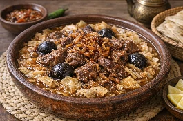 طريقة-عمل-طبق خزف تقليدي مملوء بقطع رقائق الرقش الرقيقة مغمورة بمرق اللحم البني الداكن مع قطع لحم حاشي أو غنم متفتتة وبصل محمر
