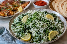 طبق سبانخ بالأرز والليمون صومالي، أرز بسمتي أبيض مفلفل مختلط بسبانخ خضراء زاهية وقطع ليمون طازج، يقدم مع سمك مشوي وصلصة هريسة حارة وخبز صومالي
