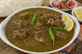 طبق ملاح ويكة سوداني تقليدي بقوام مخملي من البامية المطحونة مع قطع اللحم يقدم مع الأرز الأبيض وشرائح الليمون والفلفل الأخضر الحار