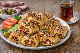 طريقة-عمل-بوريك تركي ذهبي مقرمش محشو بالسجق الحار ومغطى بالسمسم وحبة البركة مع كوب شاي تركي